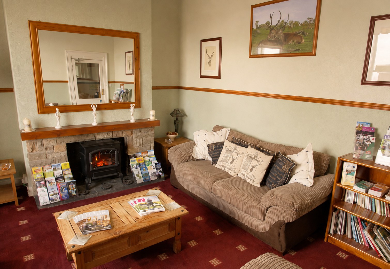 The guest lounge with a stone fireplace, sofa and bookshelves